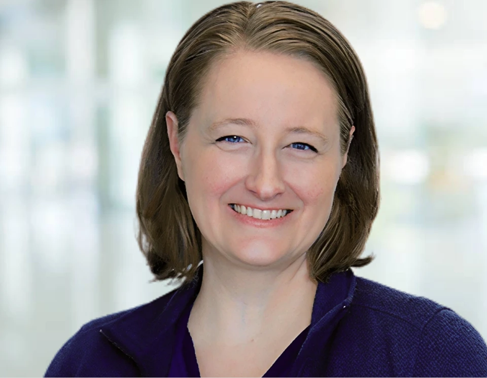 Woman with shoulder-length brown hair smiling at camera in professional headshot