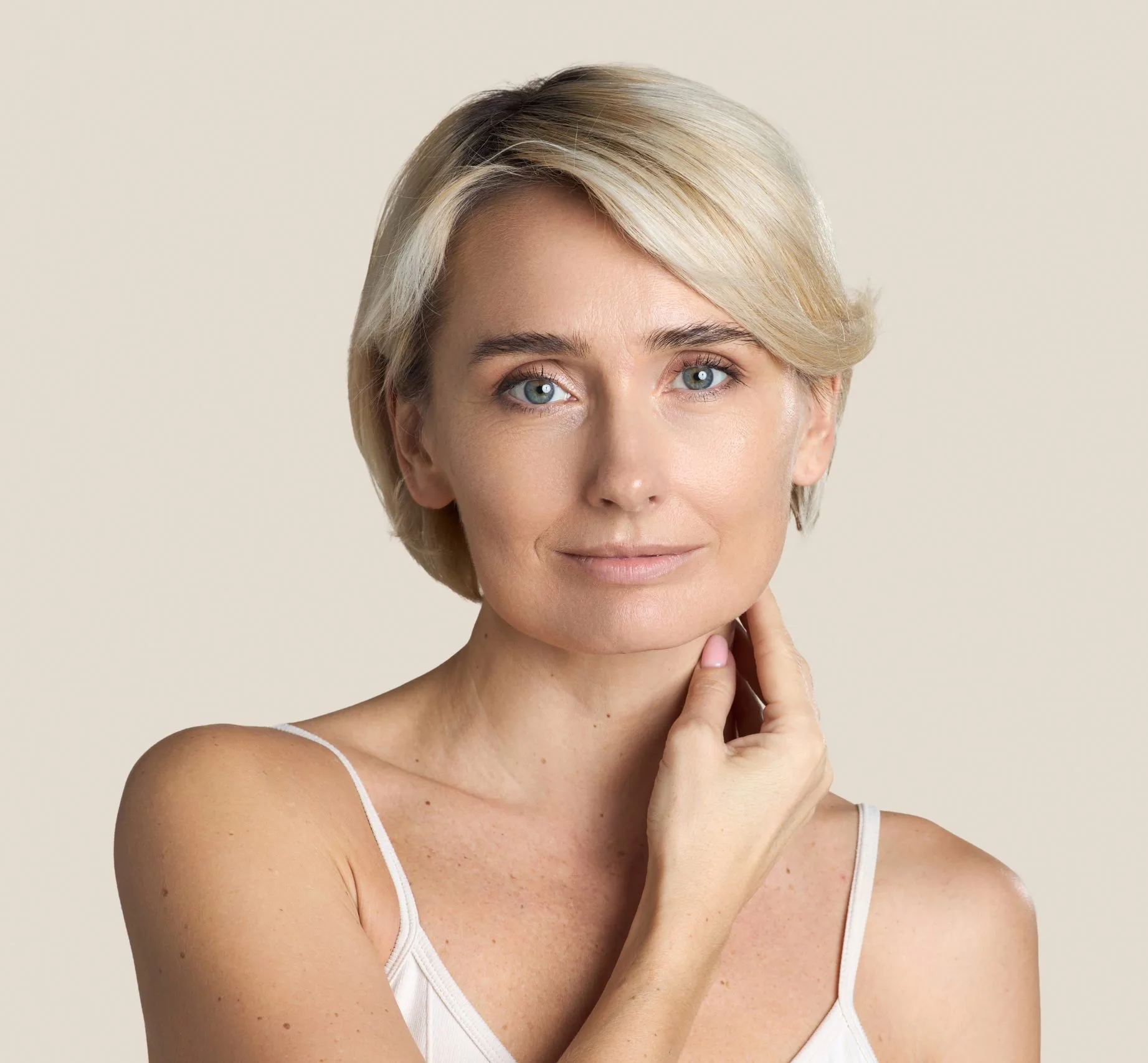Woman touching her neck and looking at camera