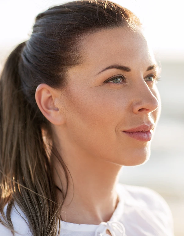 Woman in profile with smooth skin and defined facial contours in natural lighting