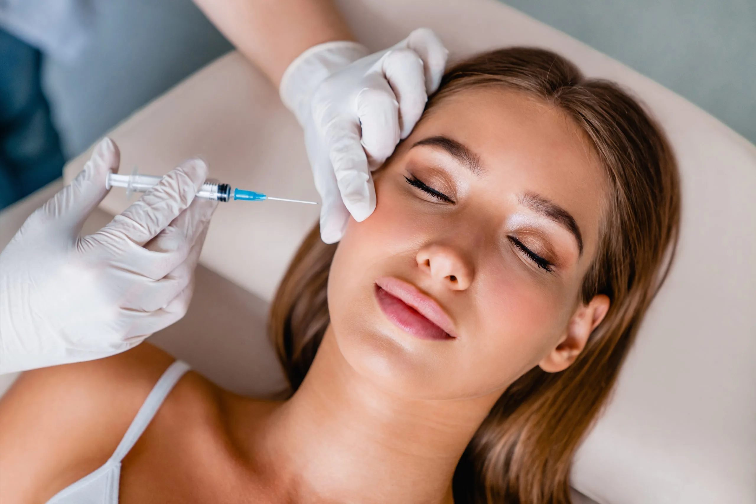 Clinician administering Botox injection to patient's forehead