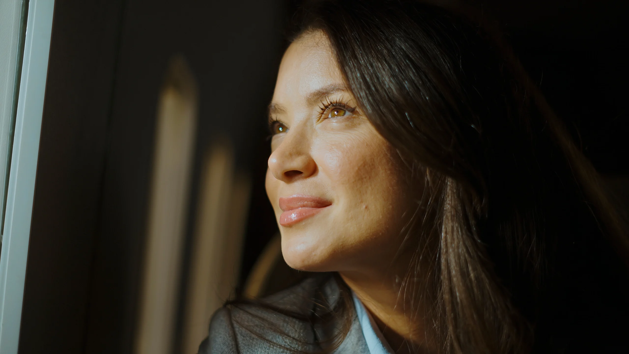 Woman in soft window light with glowing skin