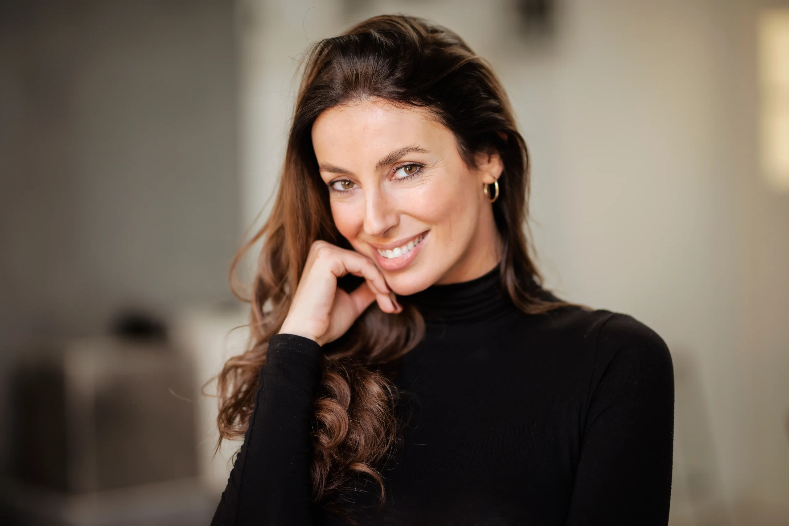 Smiling woman with long brown hair and glowing skin